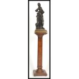 An antique style bronzed / bronze effect statue of a Dutch girl with pet lamp raised on naturalistic