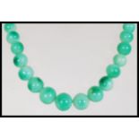 A vintage Chinese believed green jade or Peking glass prayer bead necklace having a graduating set
