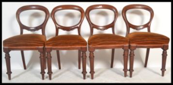 A set of four 19th Century Victorian mahogany balloon back dining chairs raised on turned and reeded
