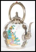 A 20th Century Chinese ceramic teapot having silver white metal mounts, spout and handle. The