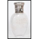 A 19th Century silver topped scent bottle having an ovoid glass body. The lid being decorated in the