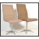 A pair of retro style contemporary swivel chairs / dining chairs, raised on chrome uprights on