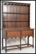 A late 20th century oak Jacobean revival dresser having upright delft plate rack with two fixed