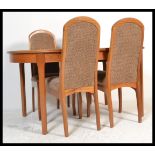 A retro 20th Century teak wood oval extendable dining table and four matching chairs by Meredew, the