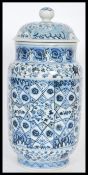 A Chinese hand painted blue and white ceramic vase and cover of cylindrical form having a bell