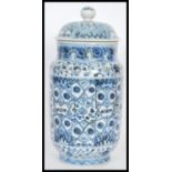 A Chinese hand painted blue and white ceramic vase and cover of cylindrical form having a bell