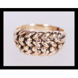A hallmarked 18ct gold ring with a woven pattern to the head. Hallmarked chester. Weight 9.8g.