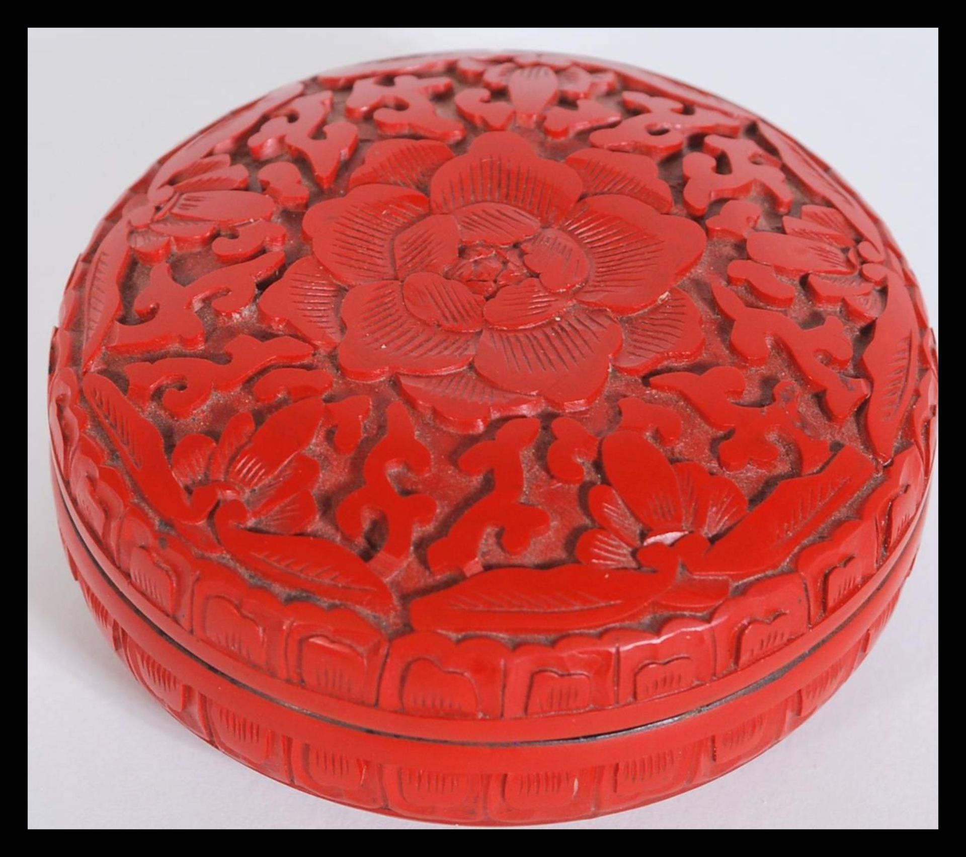 An early 20th Century Chinese Cinnabar lacquer power pot box of circular form having carved floral