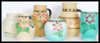 A collection of 20th Century Bretby handmade jugs having engraving floral sprays with hand painted