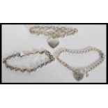 A selection of silver bracelets to include a curb link bracelet with a heart lock, a round link