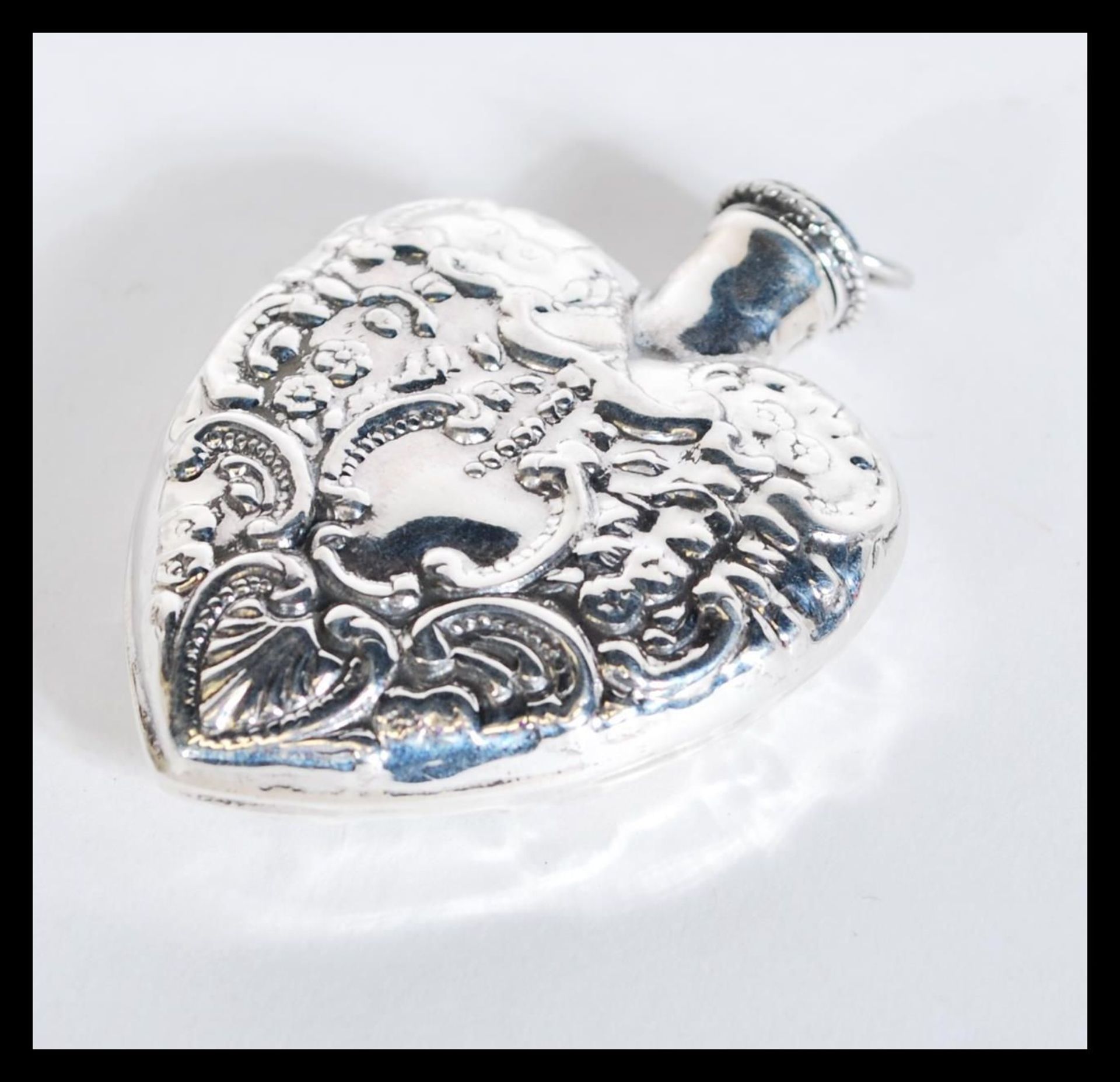 A sterling silver perfume bottle in the form of a heart having scrolled decoration. Weighs 21 grams. - Bild 2 aus 4