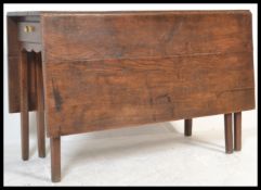 A 19th Century Georgian solid country oak large gate leg peg jointed dining / hunt table raised on