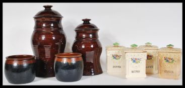 A collection of four early 20th Century Art Deco kitchen spice storage jars, with lids, the jars