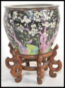 A Japanese fish bowl of bulbous form hand painted with a black ground and a pink blossom tree in