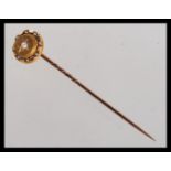 A hallmarked 15ct gold Victorian seed pearl stick pin. The pin tip to being adorned with a cluster