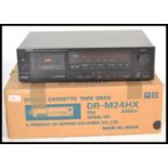 A retro Denon DR - M24Hx cassette deck tape player, having a black finish and retaining