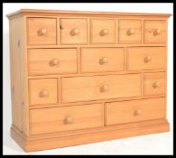 An antique style country pine chest of drawers having an unusual configuration of drawers. The