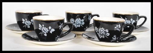 A vintage 20th Century Bristol pottery tea service having a black ground with white floral sprays