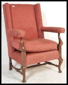 A 19th Century Georgian style wingback armchair, the shaped top rail above a padded back and deep