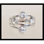 A sterling silver 925 large ring of crossover form having four large brilliant cut white stones.