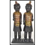 A pair of decorative 20th Century Asian carved statues depicting warriors in gilt armour with a