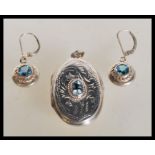 A sterling silver blue stone set locket pendant of large form along with a pair of similar