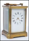 An early 20th Century brass bound carriage clock having roman numerals to the chapter ring and