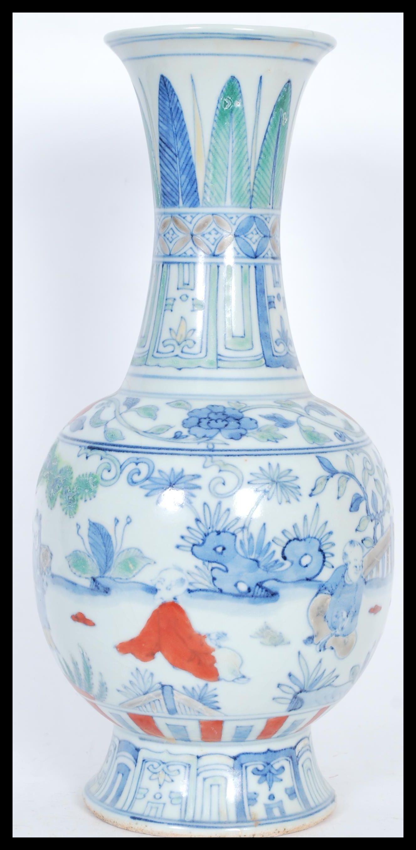 A Chinese baluster vase having hand painted decoration of children playing in scenes of trees and