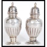 A pair of early 20thy Century hallmarked silver cruets / condiment shakers pepperettes / salt and