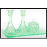 An early 20th Century Art Deco green uranium glass dressing table set comprising of a tray, candle
