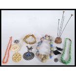 A group of vintage early 20th Century jewellery to include a carved bone pendant and brooch, coral
