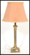 A vintage Antique style brass table lamp raised on paw feet with square base with central brass