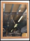A large antique style pine framed mirror of square having a central mirror panel in stepped pine