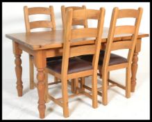 An antique style country pine dining suite consisting of a dining table raised on block and turned