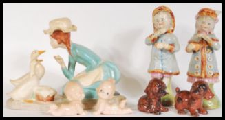 A pair of 19th Century Austrian ceramics modelled as a young boy and girl, together with a pair of