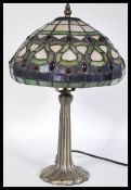 A 20th Century twin bulb Tiffany inspired table lamp, the cast base of Art Nouveau taste having a