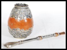 A silver covered Mate drinking gourd. The gourd having a silver white metal cover with engraved