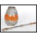 A silver covered Mate drinking gourd. The gourd having a silver white metal cover with engraved