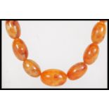 A vintage amber / faux amber Chinese prayer bead necklace having a graduating strand of beads.