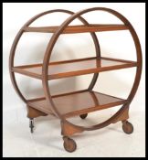 A 1930's  Art Deco walnut three - tier trolley, with circular ring supports, terminating on castors