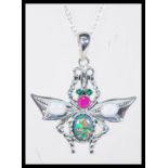 A sterling silver and opal set necklace pendant in the form of a firefly having green stone eyes and