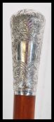 A malacca walking stick cane having a silver white metal knop to the top with foliate decoration and