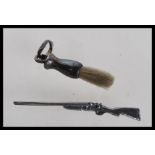 A silver miniature doll's house side by side shotgun along with a miniature brush with a loop finial