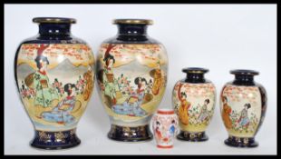 A set of four graduating 20th Century Japanese vases having cream hand painted narrative panels on a