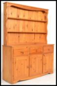 A 20th Century pine dresser having an arrangement of drawers and cupboards underneath plate rack