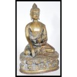 A 20th Century bronze figure of a Buddha in the lotus position wearing decorative robes with one