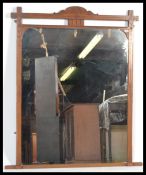 A late 19th early 20th Century Arts and Crafts ecclesiastical framed overmantel wall mirror, the