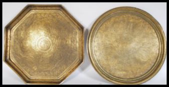 Two Indian brass charger trays to include a 19th Century example of circular form and an hexagonal
