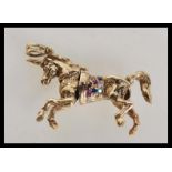 A hallmarked 9ct gold articulated necklace pendant in the form of a unicorn having inset multi