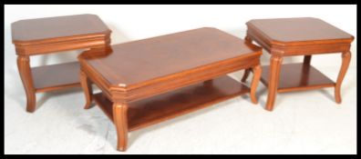 A set of three good quality hardwood coffee tables raised on shaped scrolled legs with inlaid